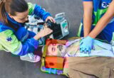 First aid, ambulance. Paramedics provide first aid to injured man with medical equipment, give