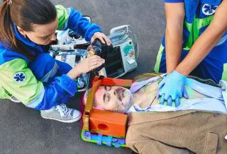 First aid, ambulance. Paramedics provide first aid to injured man with medical equipment, give