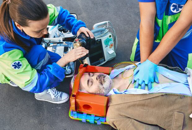 First aid, ambulance. Paramedics provide first aid to injured man with medical equipment, give