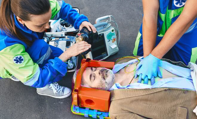 First aid, ambulance. Paramedics provide first aid to injured man with medical equipment, give