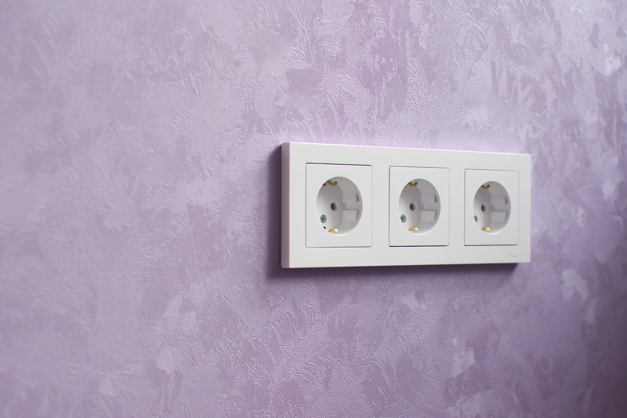 Wall socket and violet wall.